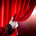 打开红色剧院帷幕的白手套手